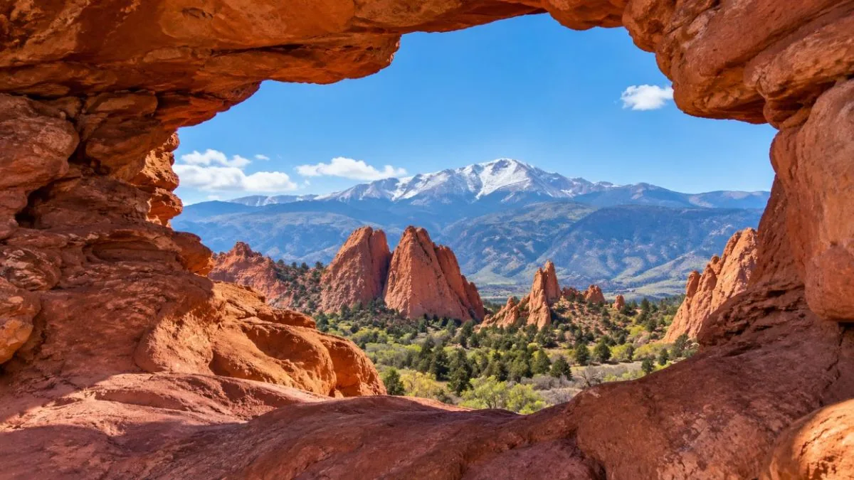 Pikes Peak framed through the natural rock window on the Siamese Twins Trail